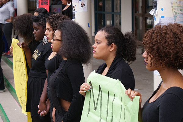 Black students staged a protest March 5th in response to the racist comment left on the now-defunct Mills College Confessions Facebook page as well as the culture of racism they feel is present at Mills at all times. Dressed in all black, the students held signs and stood silently for two hours on the Tea Shop steps. (Photo by Melodie Miu)