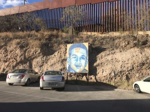 A mural of Jose Antonio Rodríguez sits in front of the border fence.